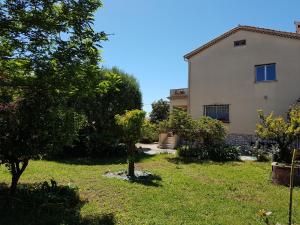 uma casa com um quintal com árvores e um edifício em Villa Calliste em Saint-Laurent-du-Var