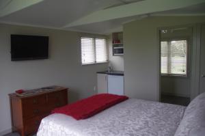 a bedroom with a bed and a flat screen tv at Serenity on Brunskill in Cambridge