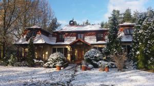 a large house with snow on the ground at Lisi Dwór in Czarny Młyn