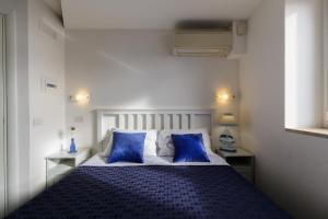 a bedroom with a blue and white bed with two blue pillows at 14 Leoni in Salerno