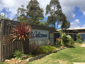 a fence with a welcome sign in a yard at A'Wangralea Caravan Park in Mallacoota