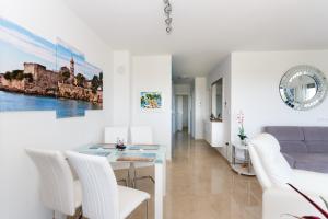 a white living room with a table and white chairs at Apartment Marinela in Krk