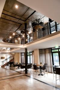 een grote kamer met tafels, stoelen en ramen bij Fletcher Hotel-Restaurant de Korenbeurs in Made