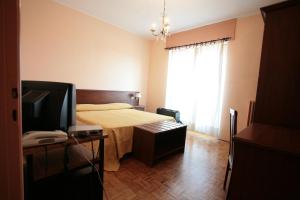 sypialnia z łóżkiem i telewizorem w obiekcie hotel ristorante vittoria w mieście Santhià
