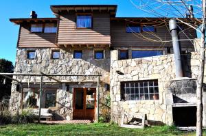 una antigua casa de piedra con puerta de madera en Casa Las Moras en San Martín de los Andes