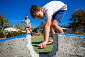 a boy and a girl are playing in a play yard at NRMA Warrnambool Riverside Holiday Park in Warrnambool