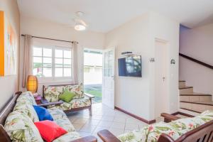 a living room with a couch and a tv at Bhaus Juqueí | Beach House | Praia in Juquei