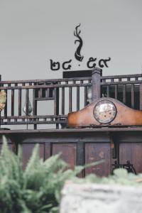 a clock sitting on top of a wooden fence at Baan 2459 in Bangkok