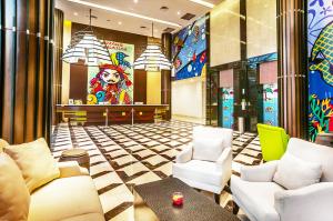 a lobby of a restaurant with chairs and a bar at MaxOneHotels at Resort Makassar in Makassar