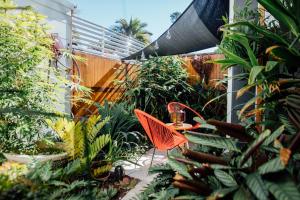 a patio with an orange table and chairs in a garden at BULC Boutique Bed & Breakfast in Belmont