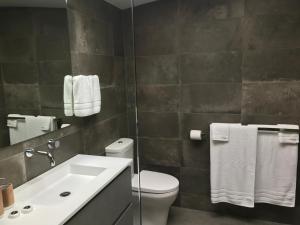 a bathroom with a white toilet and a sink at BULC Boutique Bed & Breakfast in Belmont