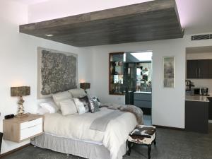 a bedroom with a large bed and a kitchen at BULC Boutique Bed & Breakfast in Belmont