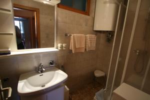 ein Bad mit einem Waschbecken, einem Spiegel und einer Dusche in der Unterkunft Pension Seevilla Annelies in Maria Wörth