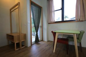 a room with a table and a chair and a window at Country Living Home Stay in Jian
