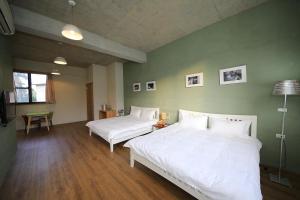 two beds in a room with green walls and wooden floors at Country Living Home Stay in Jian