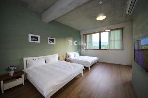 a bedroom with two beds and a flat screen tv at Country Living Home Stay in Jian