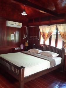 a bedroom with a large bed with white sheets at Baan Kong Homestay in Phra Nakhon Si Ayutthaya