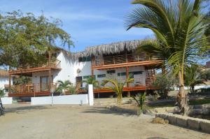 un complejo con una palmera delante de él en Casa BlueSky, en Los Órganos