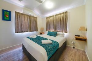 a bedroom with a large bed with a blue blanket at Capricorn Caves in Rockhampton