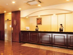 two women standing in front of a mirror at Komagane Premont Hotel in Komagane