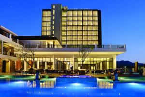 a building with a swimming pool in front of a building at Lombok Astoria Hotel in Mataram