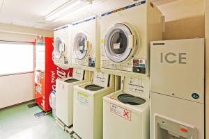 a laundry room with several washers and dryers at Komagane Premont Hotel in Komagane
