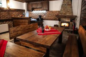 a kitchen with a wooden table and a fireplace at Yancheva Guest House in Delchevo