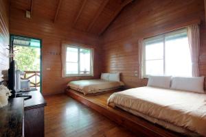 仁愛鄉的住宿－清境小太陽景觀木屋 ，木制客房内的一间卧室配有两张床