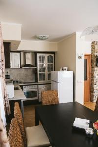 a kitchen with a black table and a white refrigerator at Villa Maria, Complex Aleksandria in Dobrinishte +44 photos