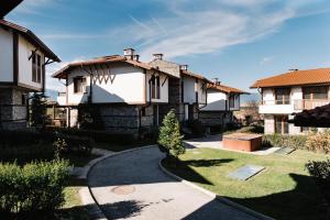 une rangée de maisons avec une passerelle dans une cour dans l'établissement Villa Maria, Complex Aleksandria, à Dobrinichte