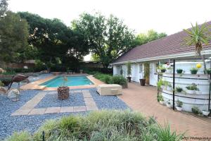 a backyard with a swimming pool and a house at Wilger Guesthouse in Centurion