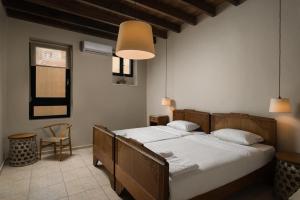 a bedroom with a bed and a lamp at Nonnalena Boutique Hotel in Chania