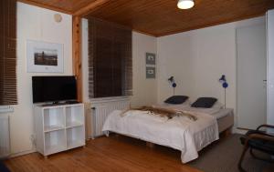 Un dormitorio con dos camas y un televisor de pantalla plana. en B&B RukaTupa, en Ruka