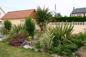 un jardín con plantas y flores frente a una casa en Gite des galets en Saint-Léonard