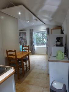 a kitchen with a table and a refrigerator at Ia Ora Na in Fréjus