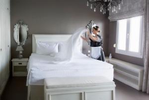 a woman is standing next to a bed at Golden Star City Resort in Perea