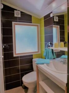 Un baño con un inodoro blanco y un lavabo. en Ia Ora Na, en Fréjus