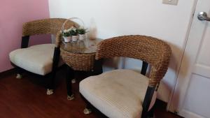 duas cadeiras de vime e uma mesa de vidro com duas cadeiras em Breadtree Homestay em Wujie
