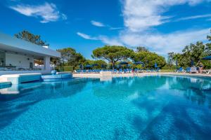 a large swimming pool with blue water at BmyGuest - Quinta do Lago Terrace Apartment I in Quinta do Lago