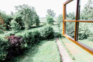 ein offenes Fenster mit Gartenblick in der Unterkunft Wilhelmshof Feggendorf in Feggendorf