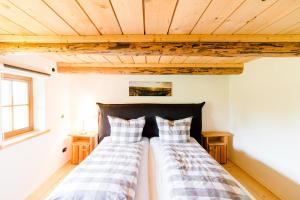 2 Betten in einem Zimmer mit Holzdecken in der Unterkunft Wilhelmshof Feggendorf in Feggendorf