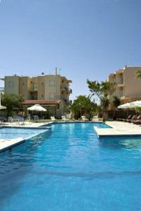 a large pool with blue water in a resort at Klonos Anna in Aegina Town