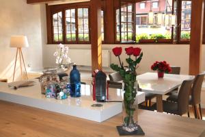 奧貝奈的住宿－La Fontaine Sainte Odile，一张桌子,上面有玫瑰花瓶