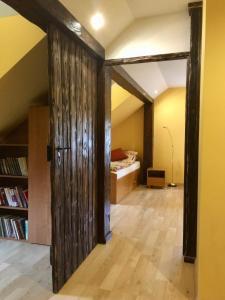 a room with a book shelf and a room with a bed at Apartament Pod Garbem in Bachórz