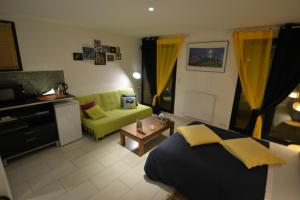 1 dormitorio con 1 cama y sala de estar con sofá en Maison d'hôtes Les Coudreaux, en Rueil-Malmaison