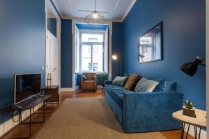 ein Wohnzimmer mit blauen Wänden und einem blauen Sofa in der Unterkunft Baixa Vintage Three-Bedroom Apartment - by LU Holidays in Lissabon