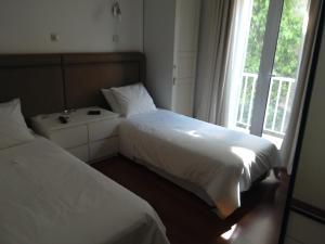 2 letti in una camera con finestra di Be My Guest Apartment ad Atene