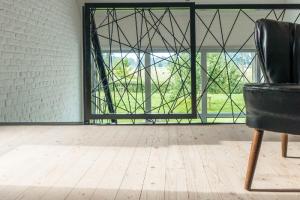 a black chair in a room with a window at De Vakantieschuur in Sint-Laureins