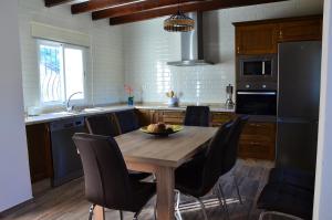 a kitchen with a wooden table and black chairs at Valley View in El Chorro