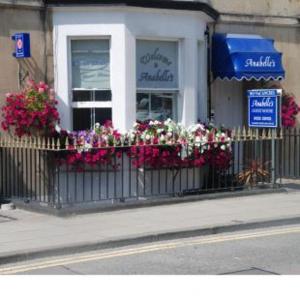 a store with flowers in front of a window at Anabelle's Guest House in Bath